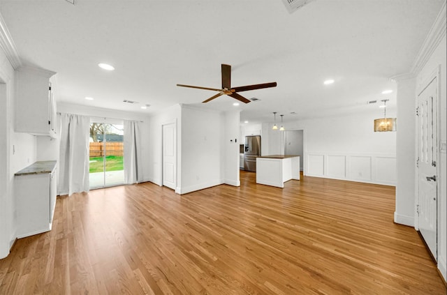 unfurnished living room with ornamental molding, ceiling fan, and light hardwood / wood-style flooring