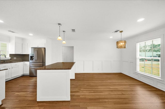 kitchen featuring sink, white cabinets, hanging light fixtures, a center island, and stainless steel refrigerator with ice dispenser