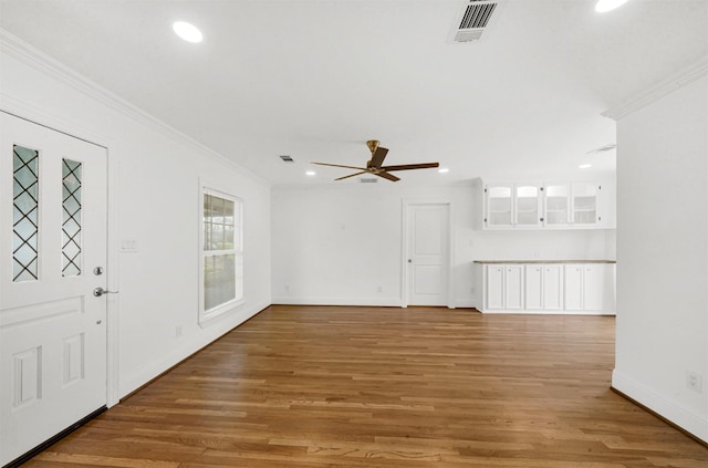 unfurnished living room featuring crown molding, ceiling fan, and wood-type flooring