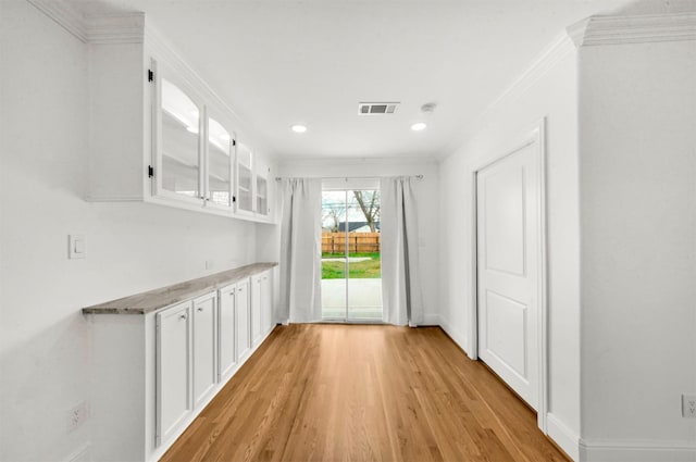 interior space with crown molding and light hardwood / wood-style flooring