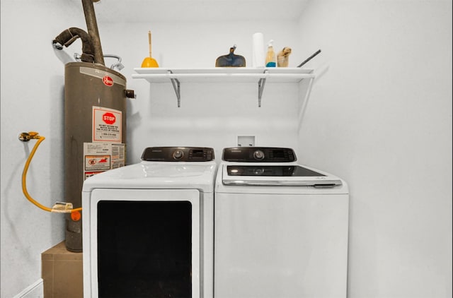 clothes washing area featuring water heater and washing machine and clothes dryer