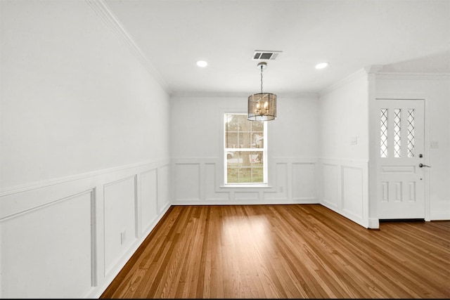 unfurnished dining area with ornamental molding and light hardwood / wood-style flooring