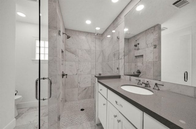 bathroom featuring vanity, an enclosed shower, and toilet