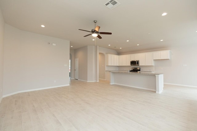 unfurnished living room featuring light hardwood / wood-style flooring and ceiling fan