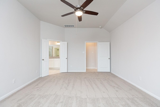 unfurnished bedroom with ceiling fan, lofted ceiling, connected bathroom, and light carpet