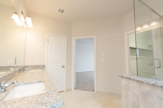 bathroom featuring vanity, a shower with shower door, and a chandelier