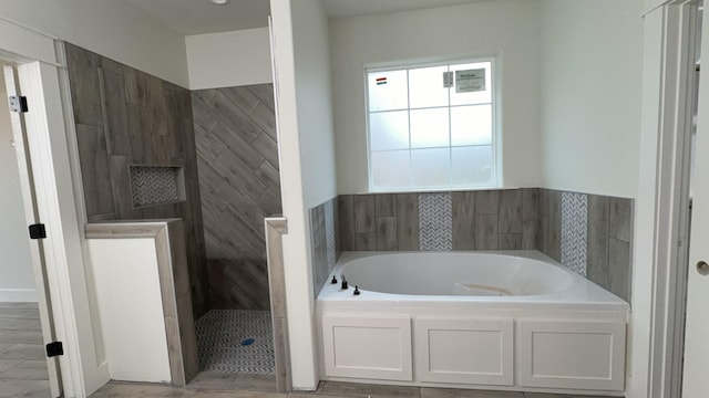 bathroom featuring separate shower and tub