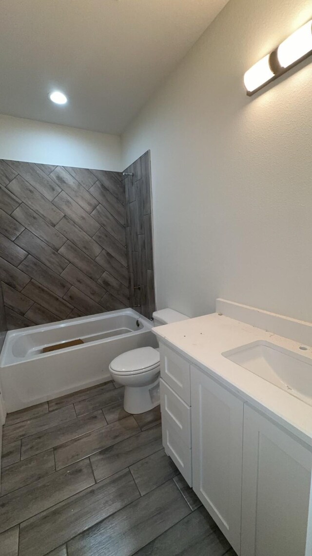 full bathroom with tiled shower / bath, vanity, and toilet