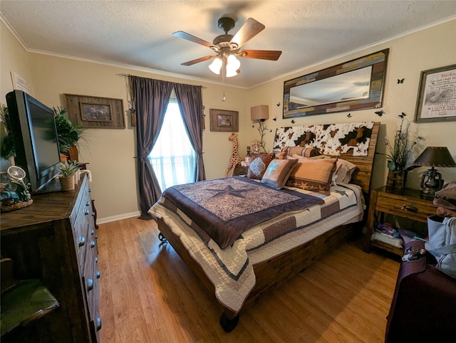 bedroom featuring light wood-type flooring, ornamental molding, and a textured ceiling