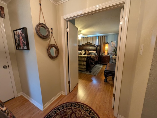 hall with light wood-style floors and baseboards