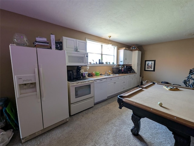 kitchen featuring pendant lighting, light countertops, white cabinets, a textured ceiling, and white appliances