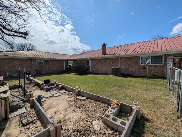 view of yard with cooling unit, fence, and a garden