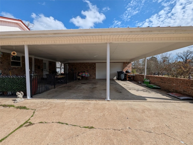 view of parking / parking lot with a garage and fence