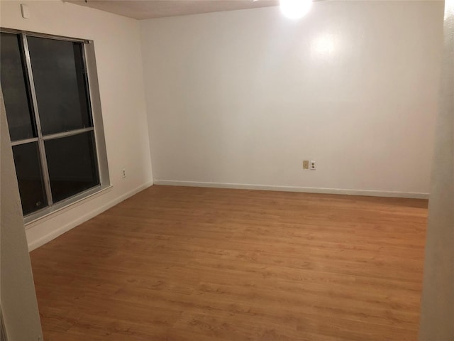 empty room with wood finished floors and baseboards