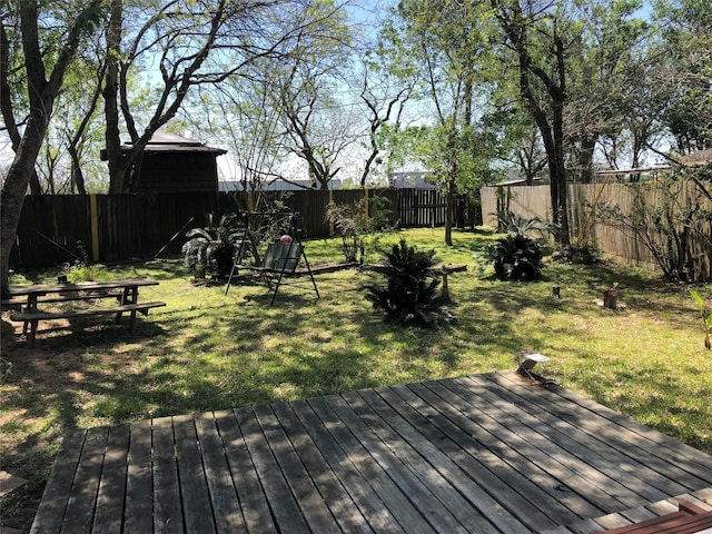 wooden terrace with a fenced backyard and a lawn