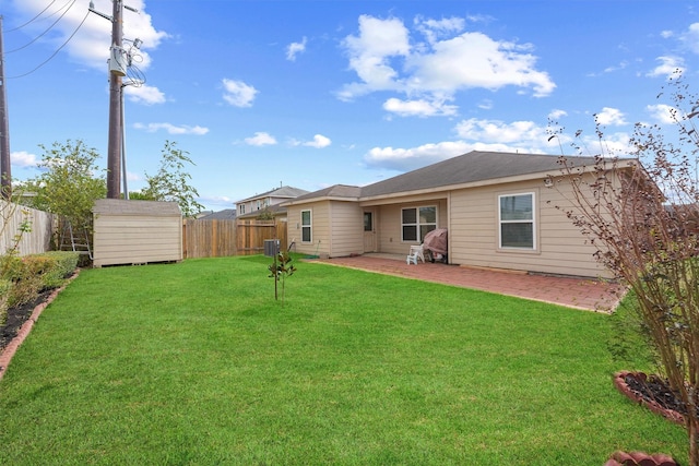 rear view of property with a yard, a shed, and a patio area