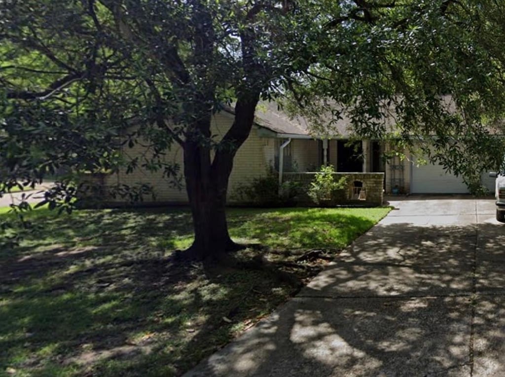 obstructed view of property with a garage and a front yard