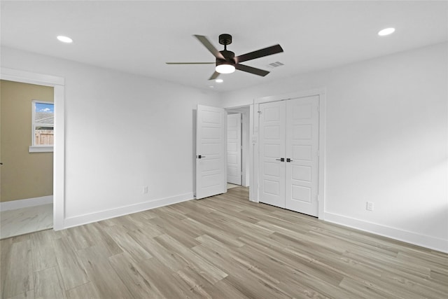 unfurnished bedroom featuring light hardwood / wood-style floors, a closet, and ceiling fan