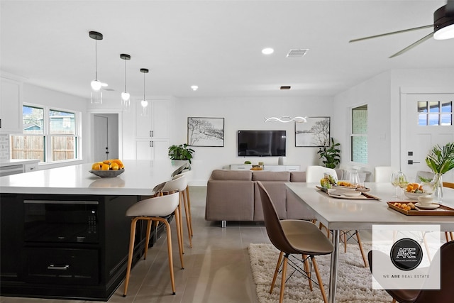 tiled dining room with ceiling fan and a wealth of natural light