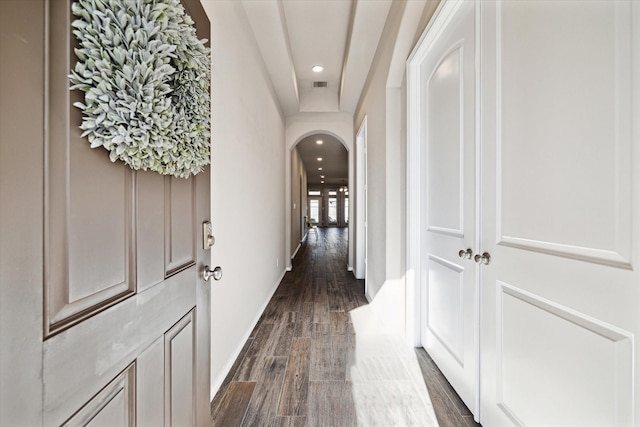 corridor with arched walkways, recessed lighting, visible vents, dark wood-type flooring, and baseboards