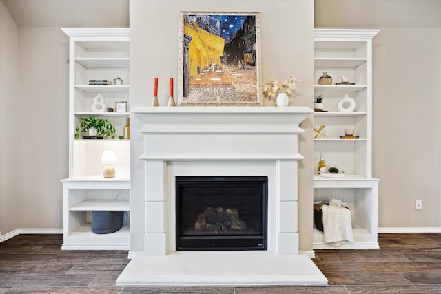 interior details with a fireplace with raised hearth, wood finished floors, and baseboards