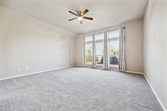 empty room with carpet floors, baseboards, vaulted ceiling, and a ceiling fan