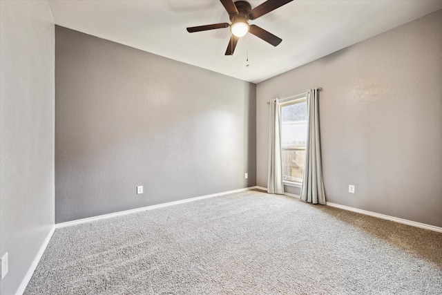 unfurnished room with carpet, a ceiling fan, and baseboards