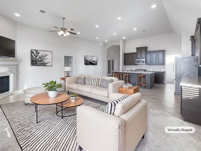 tiled living room with a towering ceiling and ceiling fan