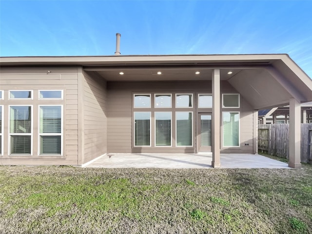 back of house with a patio area and a lawn