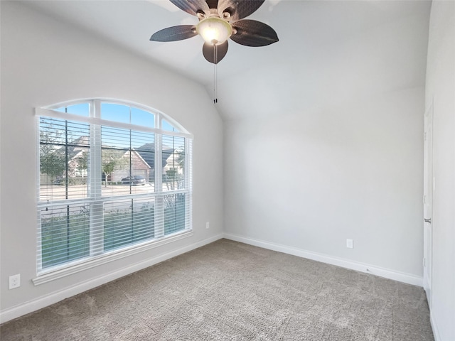 empty room with lofted ceiling, ceiling fan, and carpet