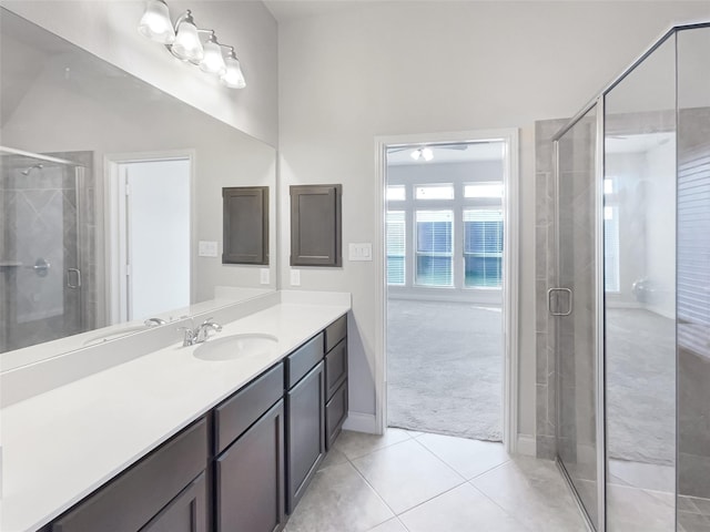 bathroom with walk in shower, vanity, and tile patterned flooring