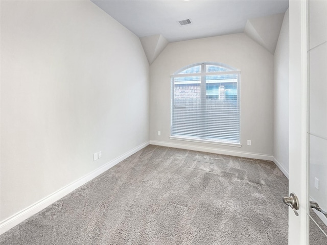 empty room featuring carpet and lofted ceiling