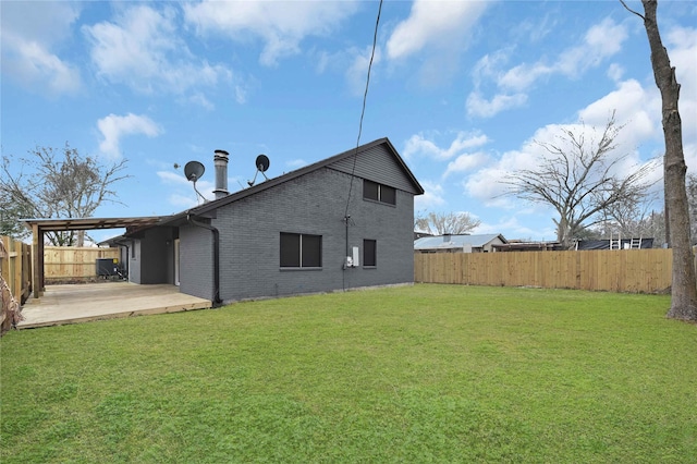 rear view of house featuring a yard and a patio area