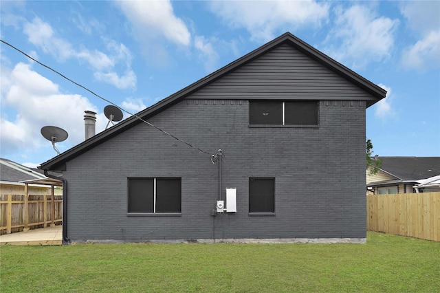 rear view of house with a patio area and a lawn