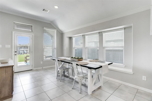 dining room with lofted ceiling, light tile patterned floors, and ornamental molding