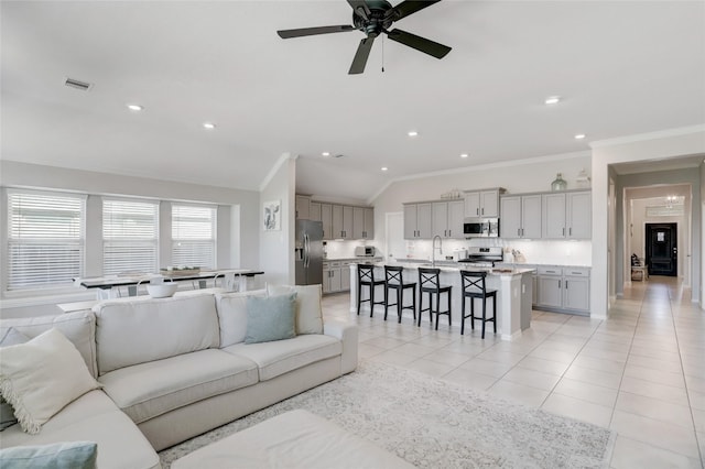 tiled living room with lofted ceiling, sink, ornamental molding, and ceiling fan