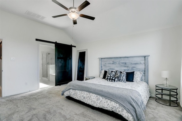 carpeted bedroom featuring ceiling fan, a barn door, vaulted ceiling, and ensuite bath