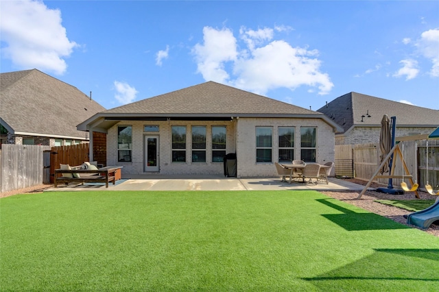 rear view of property featuring a playground, a patio, and a lawn