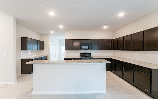 13301 Villa Sola Dr, La Marque, TX 77568 - kitchen with dark brown cabinets, a kitchen island, stove, light stone countertops, and backsplash