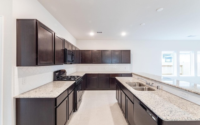 13301 Villa Sola Dr, La Marque, TX 77568 - kitchen with sink, tasteful backsplash, dark brown cabinets, light stone countertops, and black appliances