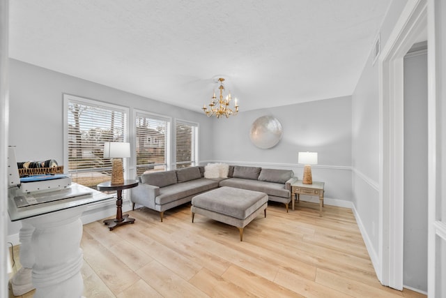 living room with a chandelier and light hardwood / wood-style floors