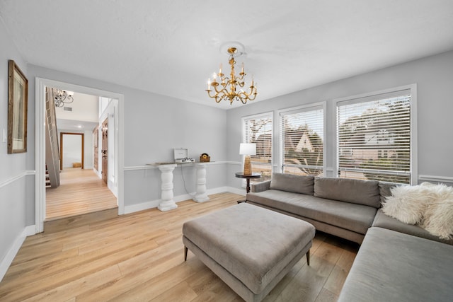 living room with light hardwood / wood-style flooring and a notable chandelier