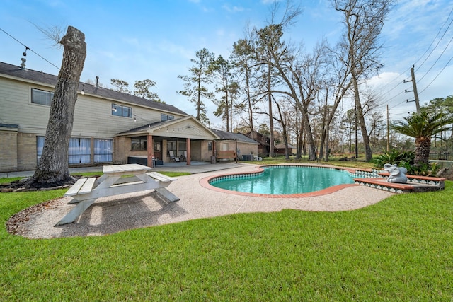 view of swimming pool featuring a yard and a patio area