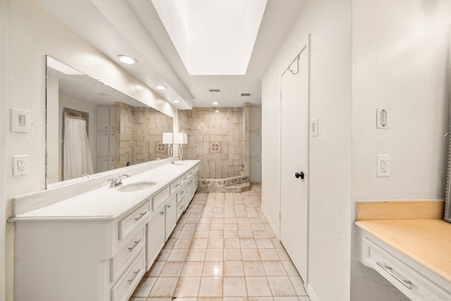 bathroom with tile patterned floors, a skylight, and vanity