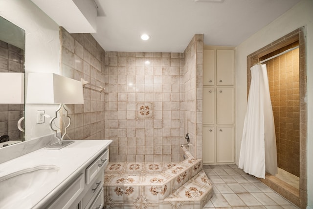 bathroom featuring vanity, plus walk in shower, tile patterned flooring, and tile walls