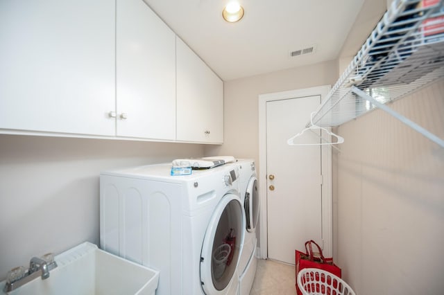 washroom with sink, cabinets, and independent washer and dryer