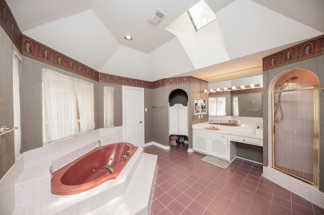 bathroom with tile patterned floors, vanity, lofted ceiling with skylight, and independent shower and bath