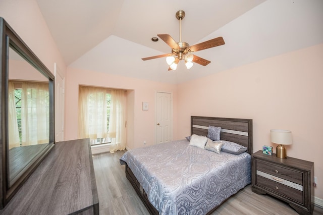 bedroom featuring ceiling fan, vaulted ceiling, and light wood-type flooring