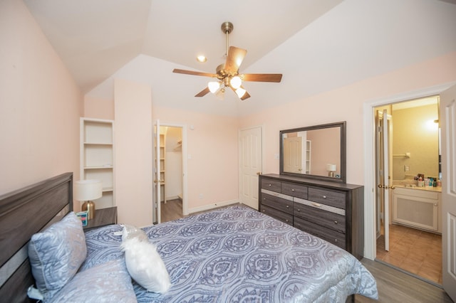 bedroom with lofted ceiling, a spacious closet, ceiling fan, and ensuite bathroom