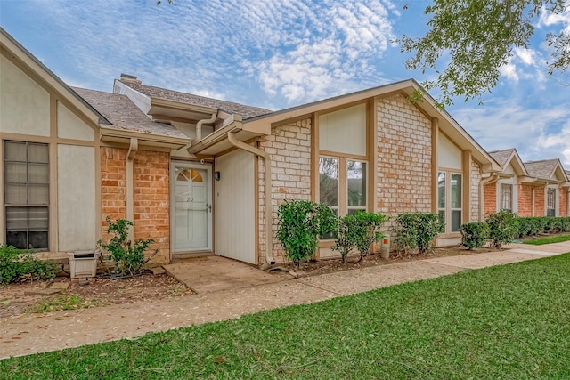 view of exterior entry with a yard